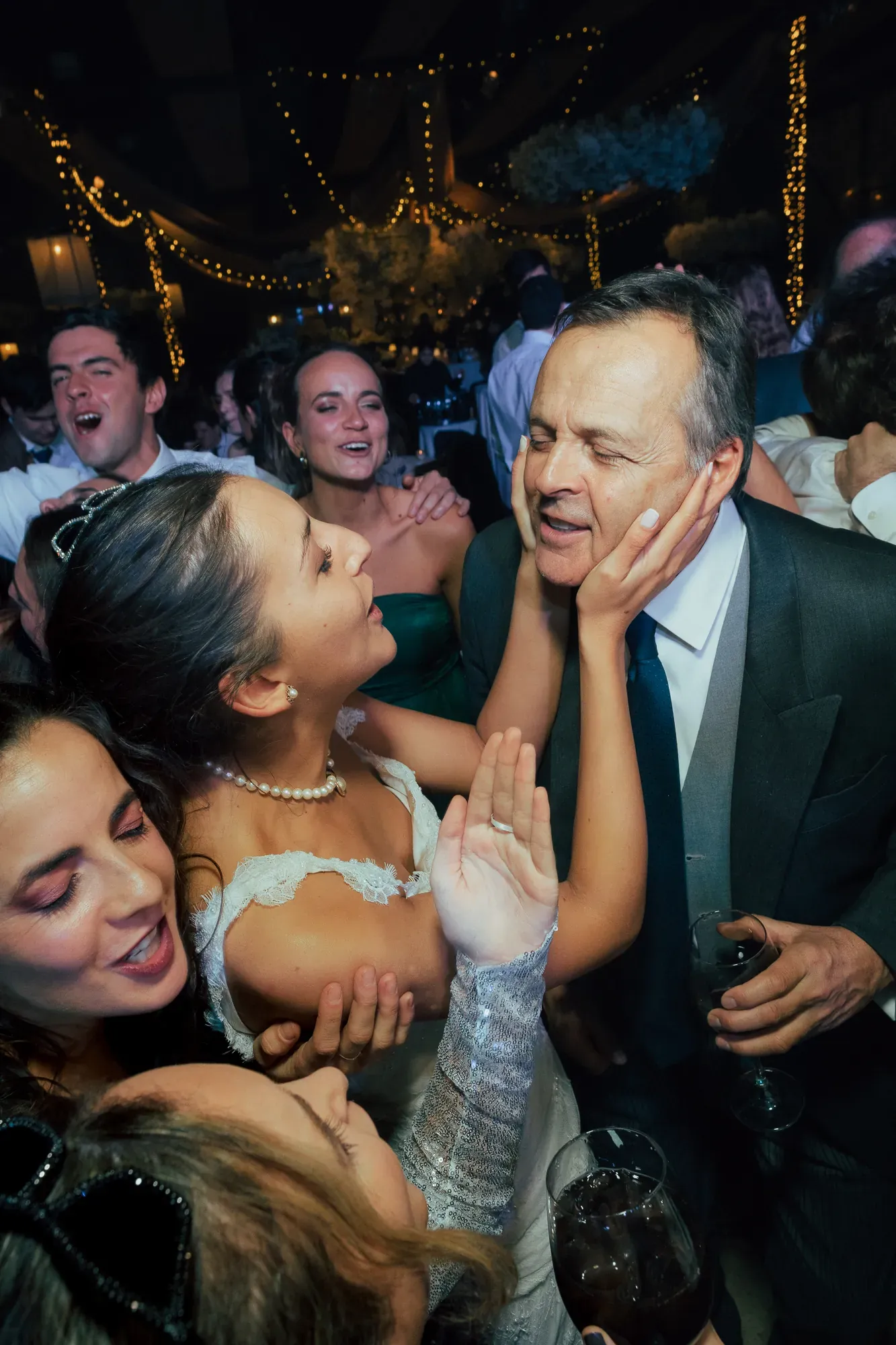 La novia toma la cara de un invitado en medio de la fiesta