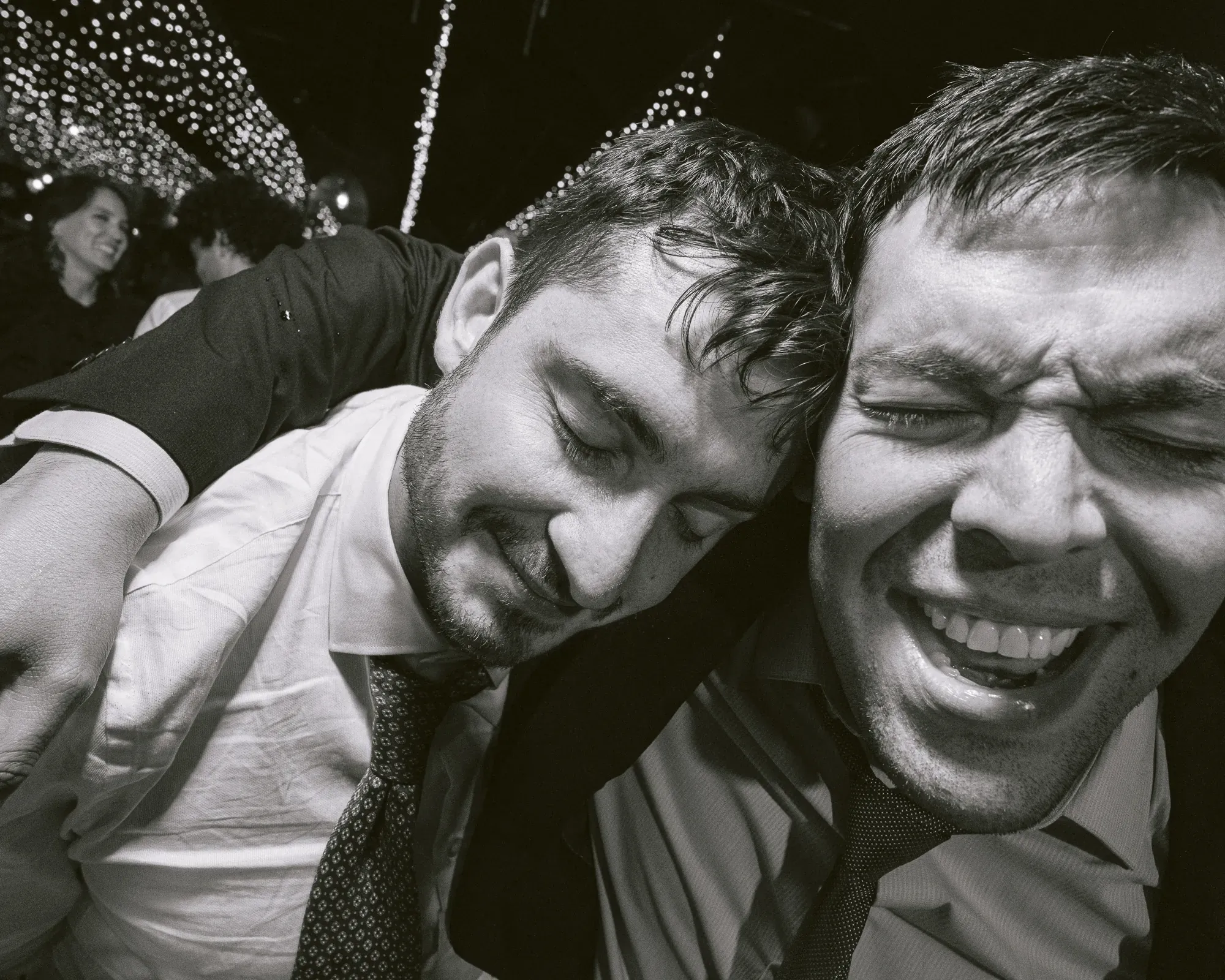 Dos amigos se abrazan riendo en la fiesta