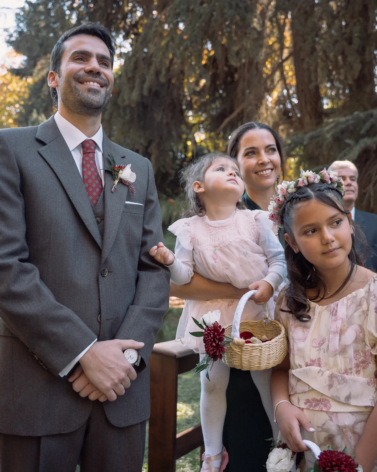 El novio espera en el altar, junto a niñas con canastos de pétalos