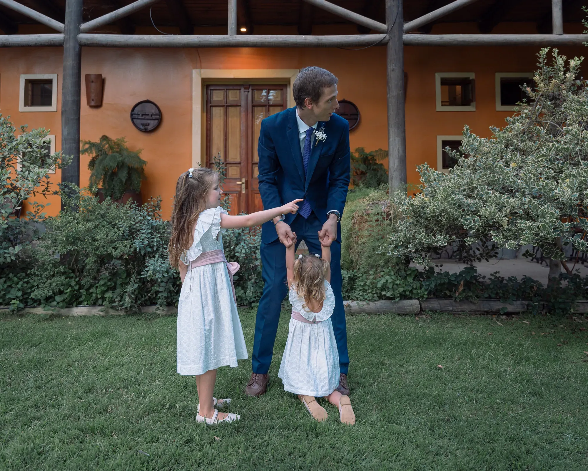 El novio juega con dos niñas en el pasto